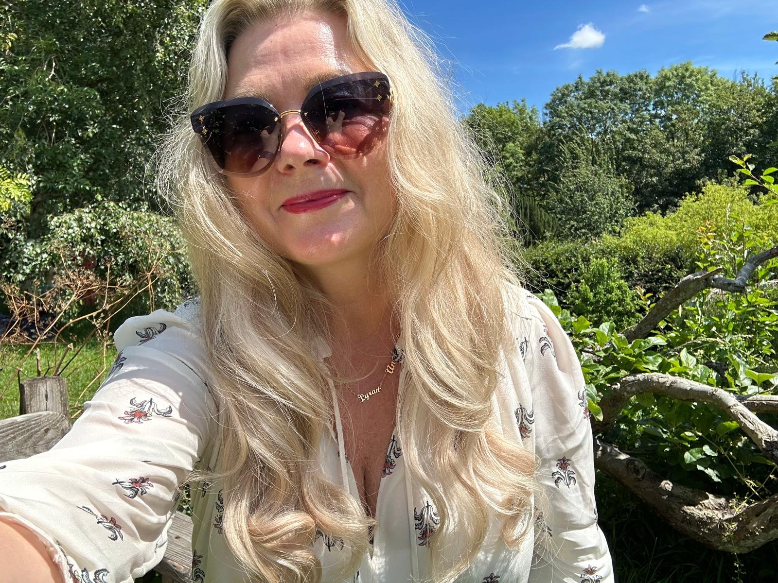 The Galactic High Priestess among yellow roses under a blue sky